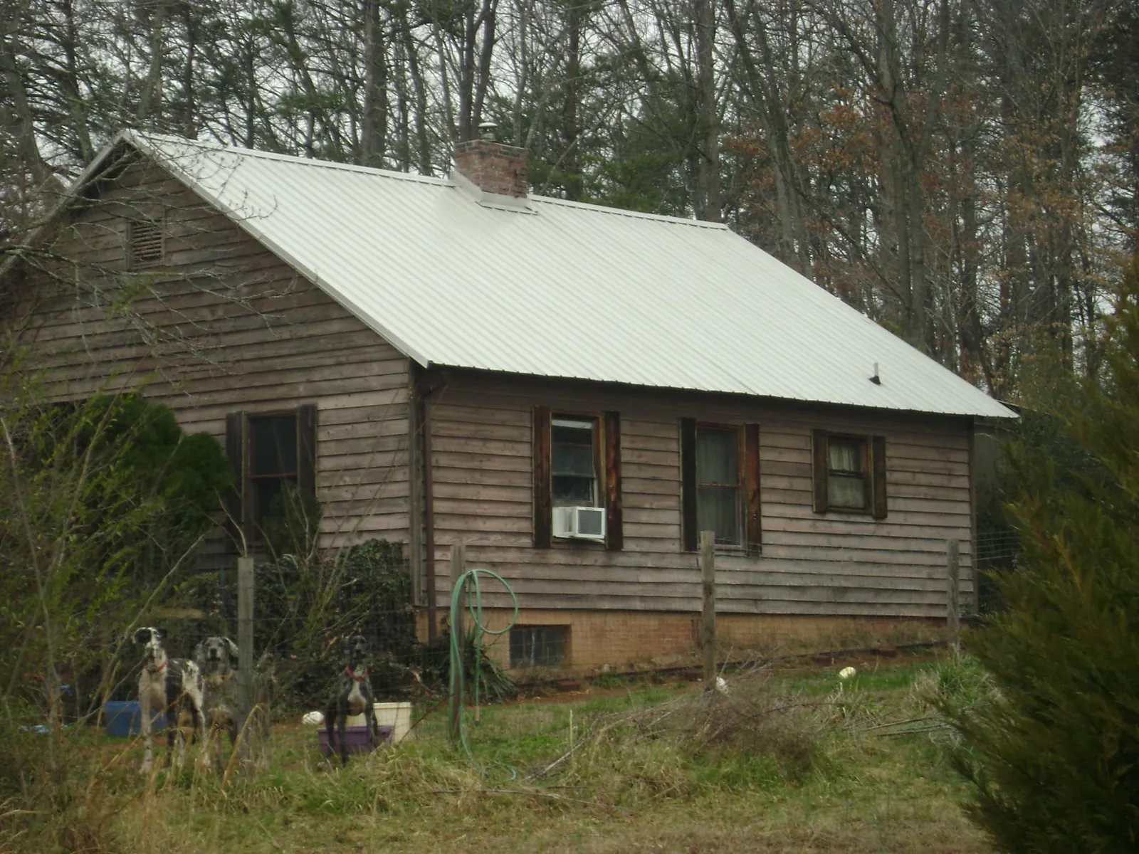 White metal roof on an old wood sided farmhouse, from a Asphalt Shingle Roof Repair job in Ingleside